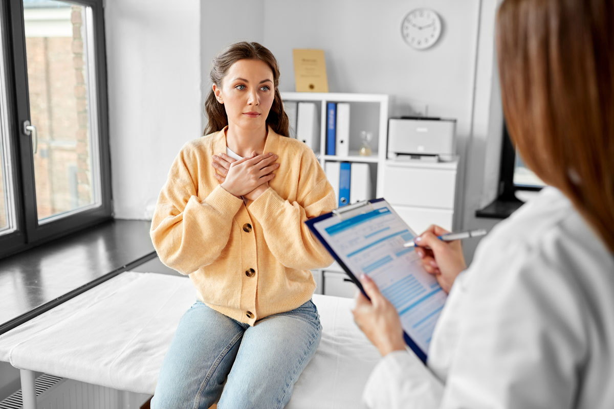 Woman at a doctor's office with hands on chest