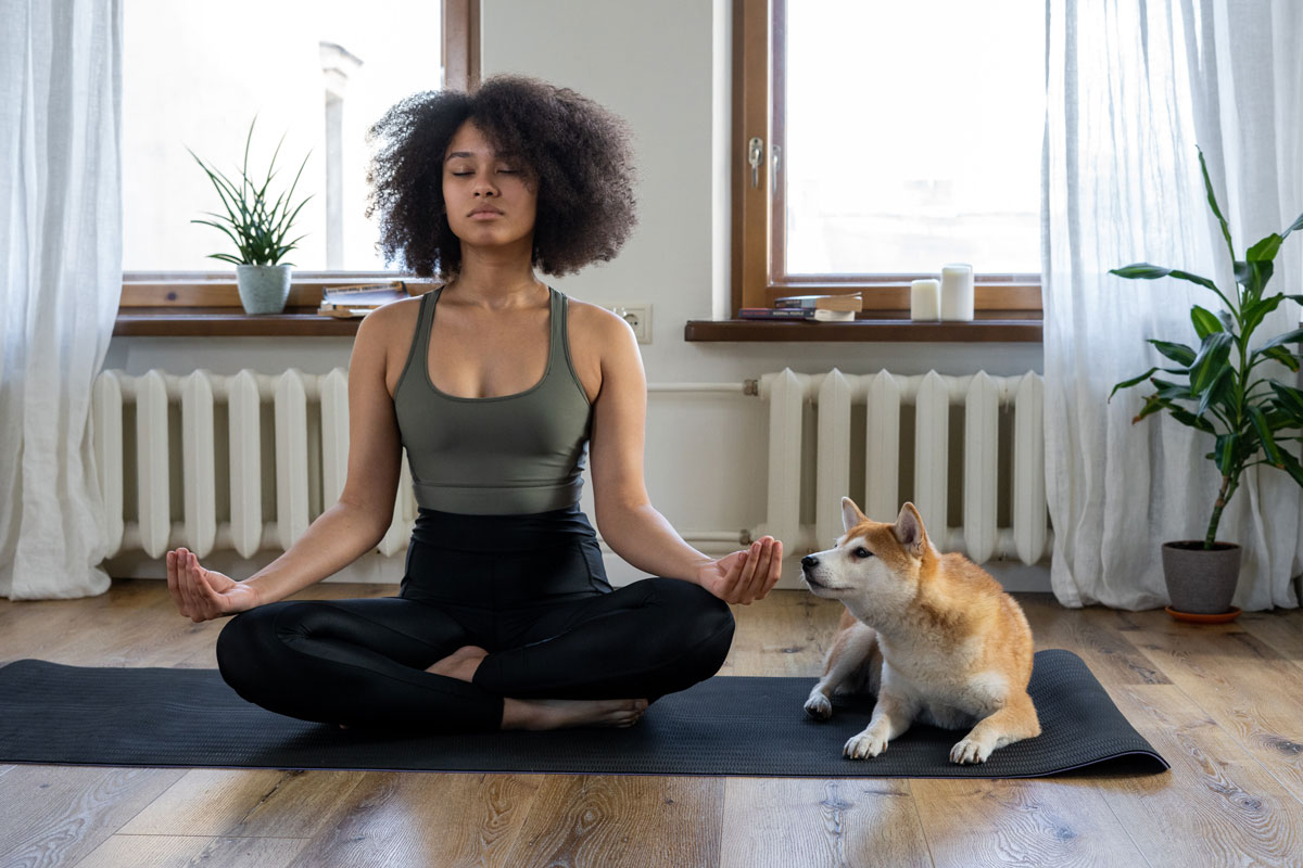 Woman meditating beside her dog