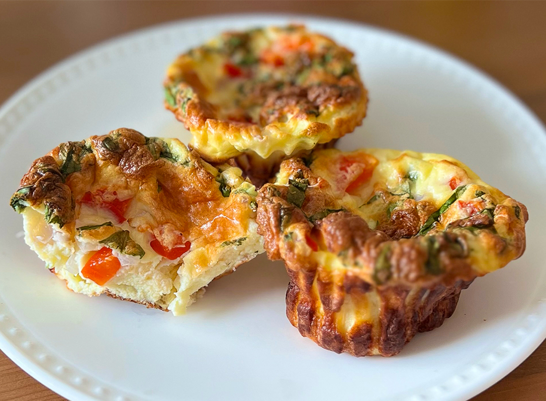 3 soft, golden, and veggie filled cottage cheese egg bites on a white plate