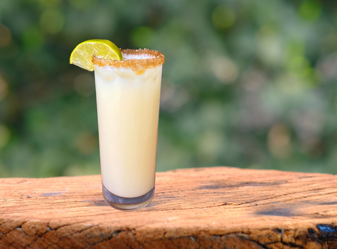 MuscleRescue Pina Colada in a sugar rimmed tall glass with a wedge of lime
