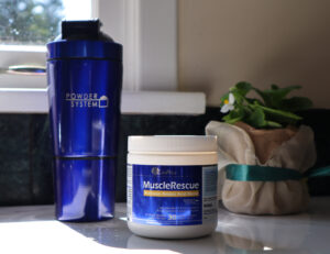 CanPrev MuscleRescue powder on kitchen counter next to water bottle 