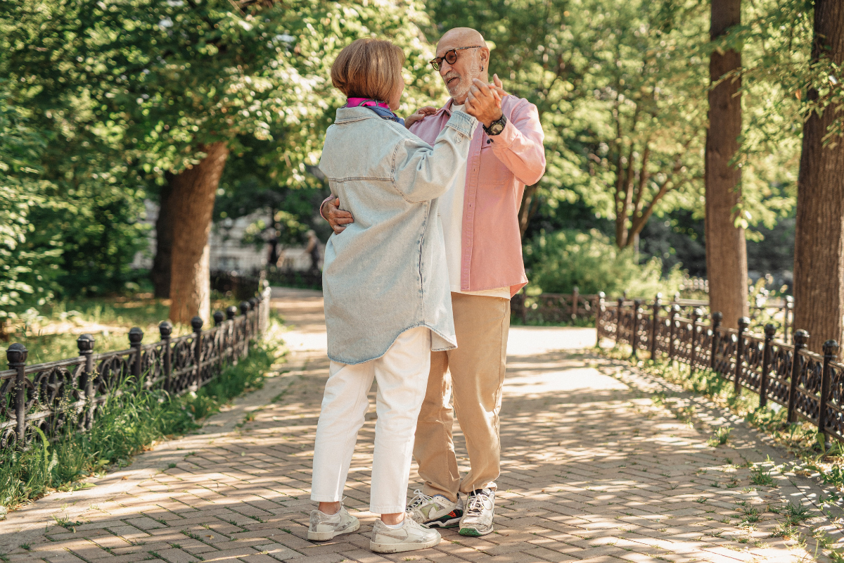 Elderly couple happily dancing outdoors