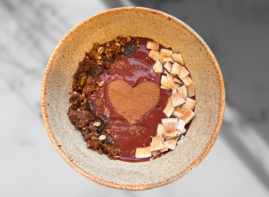 Red Velvet Beet Smoothie Bowl on a marble counter top with garnishings forming a heart in the centre of the bowl