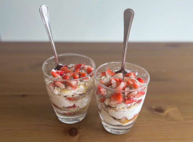 berry coconut parfait with strawberries on a wooden table