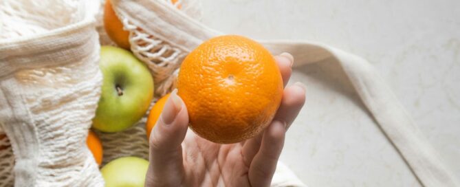 Hand holding orange fruit