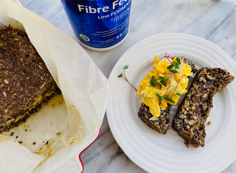 Fibre-ific Bread sliced on a plate with scrambled eggs and fresh sprouts