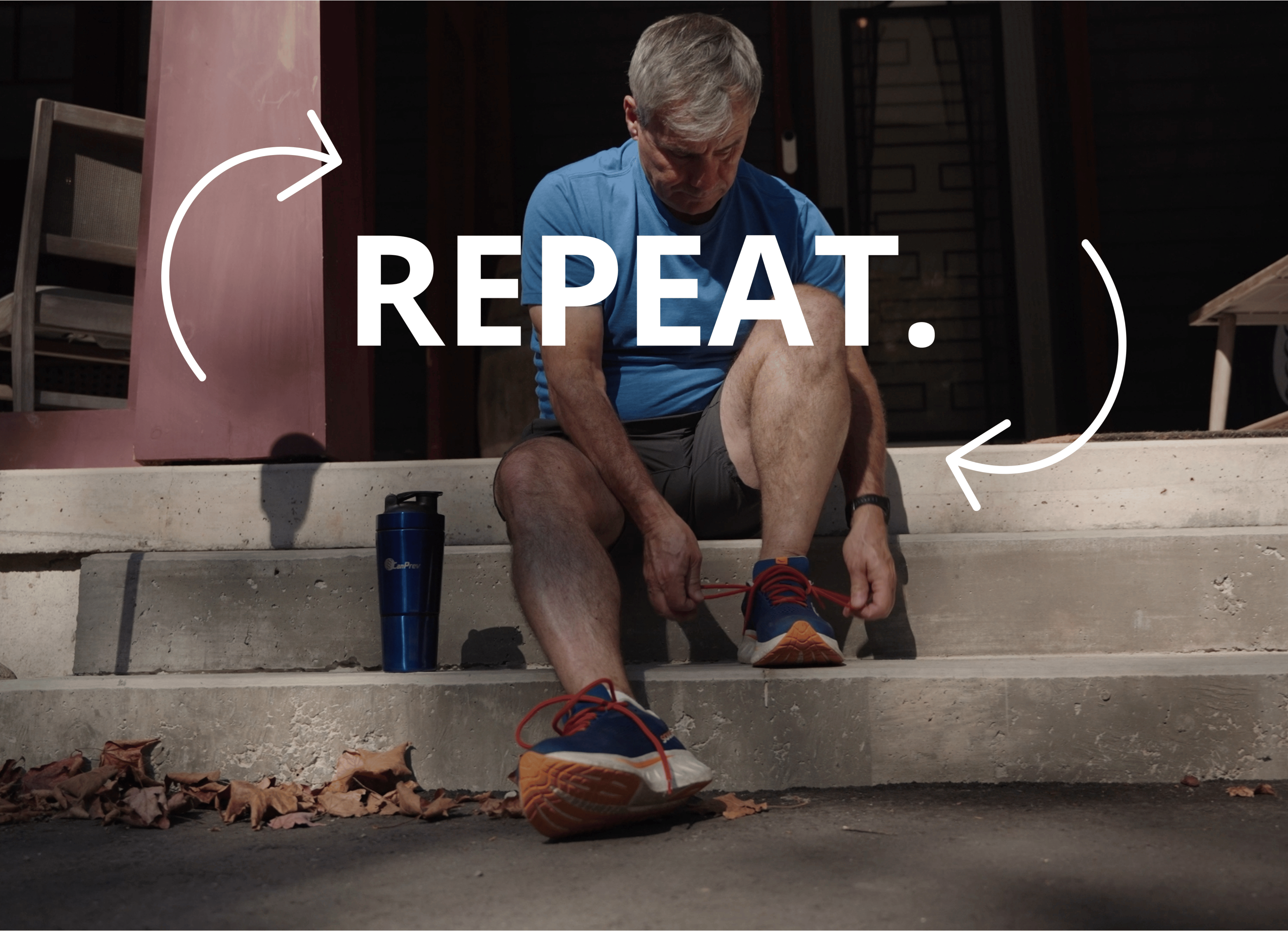 Man in a blue shirt tying his running shoes on outdoor concrete steps, with a blue water bottle nearby and autumn leaves on the ground.