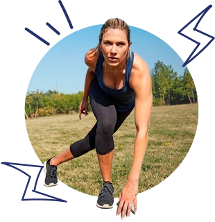 Woman in athletic wear crouches at the start line, ready to sprint on a sunny grassy field outside.
